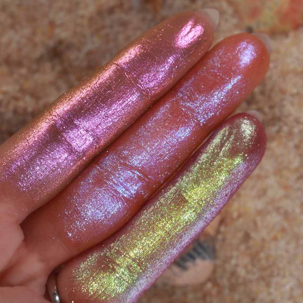 Three finger swatches of shadows from the Galápagos Palette, with sand in the background.